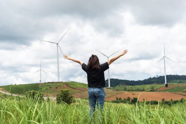 Kadın ayakta el rüzgar türbinleri karşı temiz energ üreten elektrik