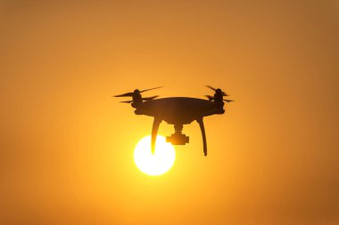 Modern teknolojik arka plan - parlayan içinde uçan dronun siluet kırmızı günbatımı gökyüzü, günbatımı üzerinde uçan uçak siluet