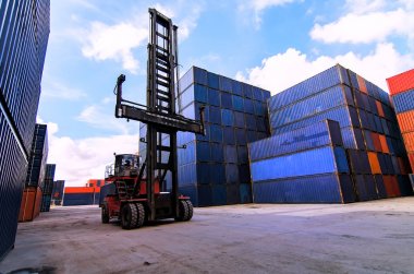 Forklift kamyon kargo konteyner nakliye bahçede kaldırma veya bahçesinde gündoğumu gökyüzü ile kargo Konteyner Taşımacılık ithalat, ihracat ve lojistik sanayi kavramı için arka plan yığınında karşı dock
