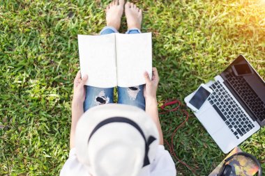 Kız zevk ağacın altında bir kitap okuma Park sabah açık çimenlerin üzerinde döşeme 