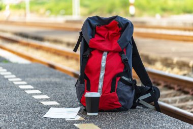 Sırt çantası, harita, cep telefonu ve dizüstü bankta tren istasyonu. Seyahat kavramı