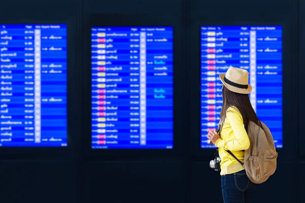 Mujer joven en el aeropuerto internacional mirando el vuelo en — Foto de Stock