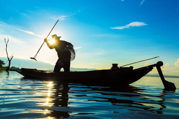 Silhueta de pescadores que utilizam redes para capturar peixes no lago em — Fotografia de Stock