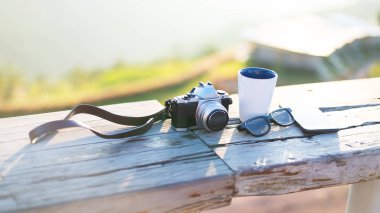 Dağların tepesinde çay fincanı ve güneş ışığı şarabı.