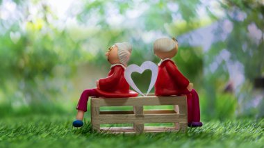 Minyatür insanlar, yeşil doğada küçük bir evi olan erkek ve kadın ilişki ve aile kavramı olarak kullanılıyor..