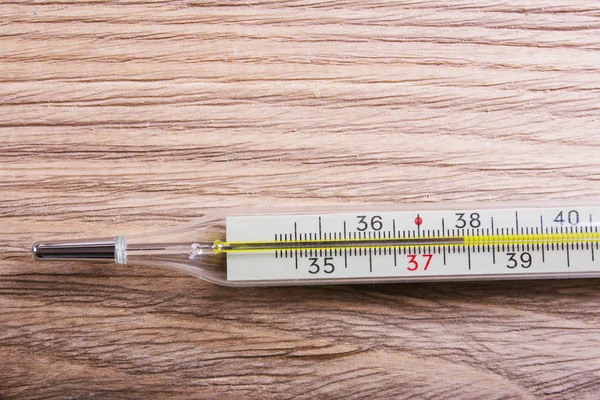 Medical  mercury thermometer on wooden table