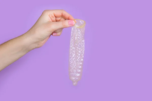 Mano sosteniendo un condón —  Fotos de Stock