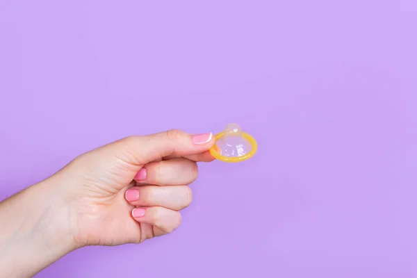 Handen håller i en kondom — Stockfoto