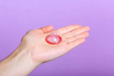 Prezervatif tutan bir el.