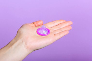 Prezervatif tutan bir el.