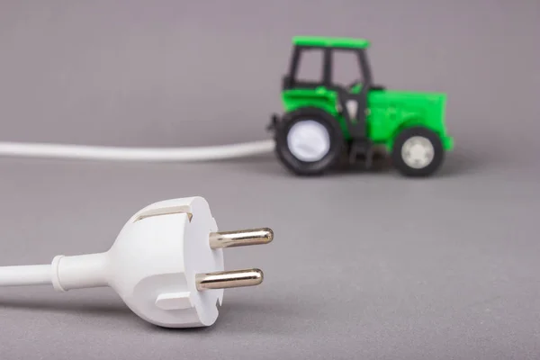 The electric tractor is charged from the outlet. Ecotech on the — Stock Photo, Image
