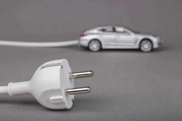 Electric car with plug from the outlet. — Stock Photo, Image