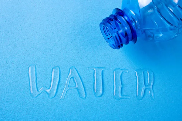 Het water is geschreven met de letters die gemorst uit de fles — Stockfoto