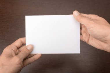 Boş kartpostal ahşap arka plan üzerinde elinde. Broşür A6 mockup