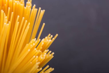 Siyah bir zemin üzerine çiğ sarı uzun spagetti yığını. Kopya S