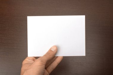 Boş kartpostal ahşap arka plan üzerinde elinde. Broşür A6 mockup