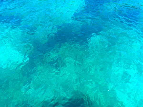 Transparent green sea water through which stones are visible — Stock Photo, Image