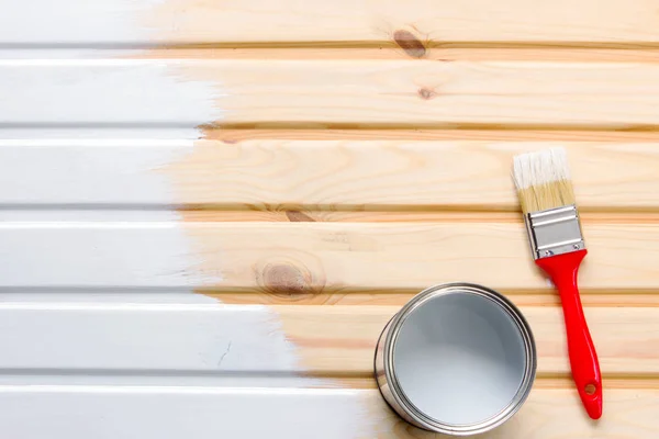 Cepillo y una lata de metal con pintura en tablas de madera. Tablero pintado — Foto de Stock