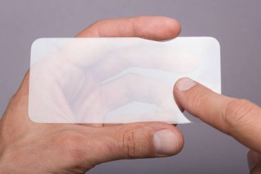 Şeffaf cam telefon bir adamın elinde. Tasarım için boş yer.