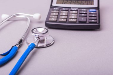 Steteskop ve gri arka plan üzerinde hesap makinesi. Sevgili tıp o