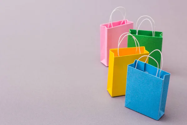 Paquetes de color para compras en un fondo gris. Copiar espacio para — Foto de Stock