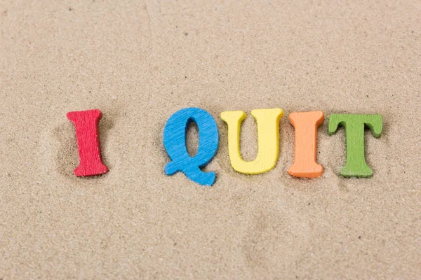 Palavra I Quit de letras de madeira coloridas na praia arenosa — Fotografia de Stock