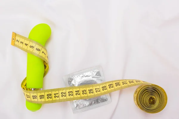 Sex for weight loss. Measuring tape and dildo with a condom. Cop — Stockfoto