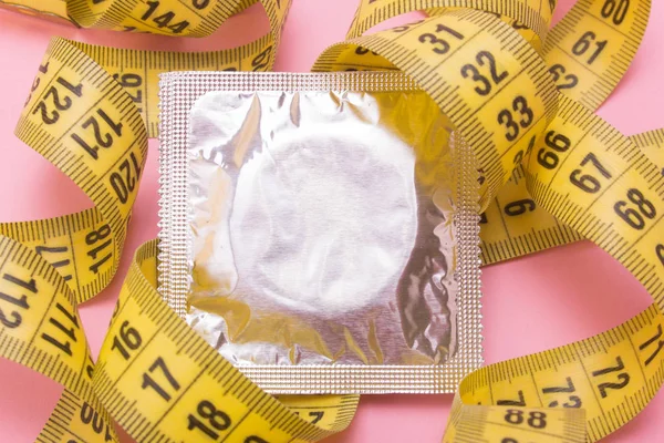 Sexo para bajar de peso. Cinta métrica y condón . — Foto de Stock
