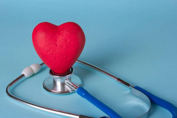 Estetoscopio y corazón sobre fondo azul. Copiar espacio para texto — Foto de Stock