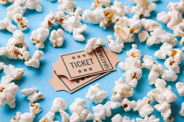 Biobiljetter och popcorn på blå bakgrund — Stockfoto