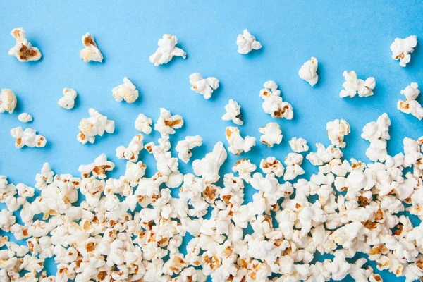 Popcorn auf blauem Hintergrund verstreut — Stockfoto