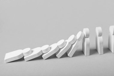 Domino etkisi iş kavramı. Beyaz küçük adamlar birbirlerine düşmek