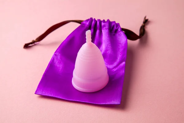 Copa menstrual de silicona. Salud de las mujeres e higiene alternativa. Fondo rosa . —  Fotos de Stock