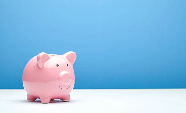 Hucha rosa sobre fondo azul. Copiar espacio para texto . — Foto de Stock