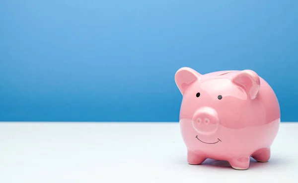 파란색 배경에 핑크 색 돼지 은행 이 있습니다. 원문을 위한 복사 공간. — 스톡 사진