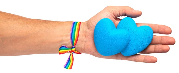 Människan håller ett hjärta i handen. Rainbow band HBTQ stolthet. Bög med blått hjärta. Isolerad på en vit bakgrund — Stockfoto