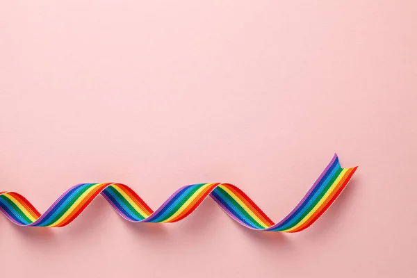 Cinta arco iris LGBT símbolo de la cinta de orgullo. Fondo rosa. Copiar espacio para texto . — Foto de Stock