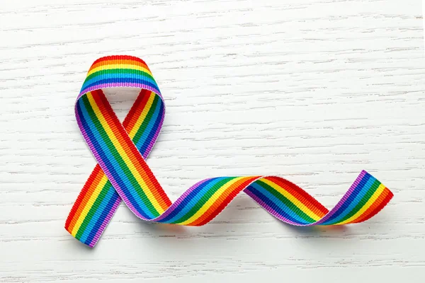 LGBT rainbow ribbon pride symbol. Stop homophobia. White wood background. Copy space for text. — Stock Photo, Image