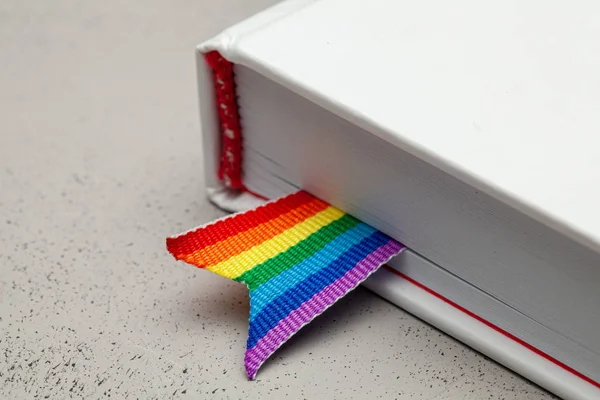 Livro com marcador e fita de arco-íris do orgulho LGBT — Fotografia de Stock