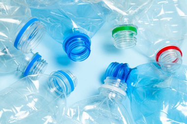 Mavi arka planda buruşmuş plastik şişeler. Plastik çöp.