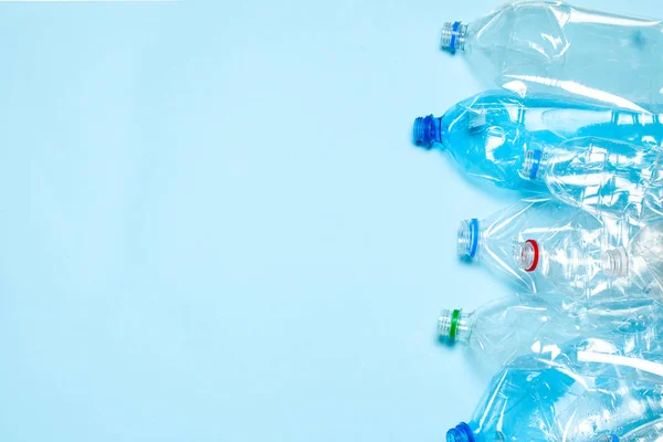 蓝色底座上皱巴巴的塑料瓶.塑料垃圾。文本的复制空间. — 图库照片