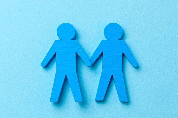 Δύο γκέι άντρες κρατιούνται χέρι-χέρι. Σε μπλε φόντο — Φωτογραφία Αρχείου