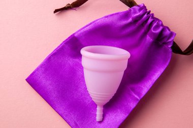 Silikon adet bardağı. Kadın sağlığı ve alternatif hijyen. Pembe arkaplan.
