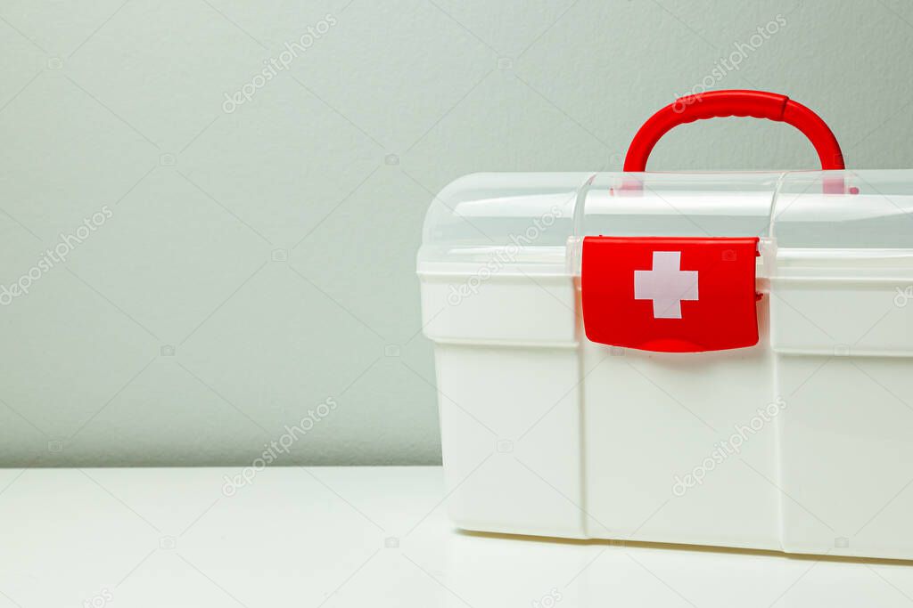First Aid Kit. White box with a cross and a red clasp on a gray background