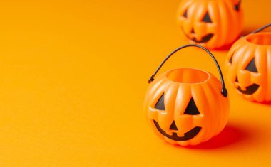 Cadılar Bayramı. Turuncu arka planda balkabağı şekeri sepeti.