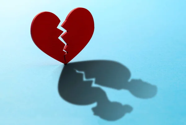 Kırık kalp. Kırmızı kalpte çatlak, ilişkiyi bozmak. Kalbin gölgesi iki kadın ve erkek figürü şeklinde. — Stok fotoğraf