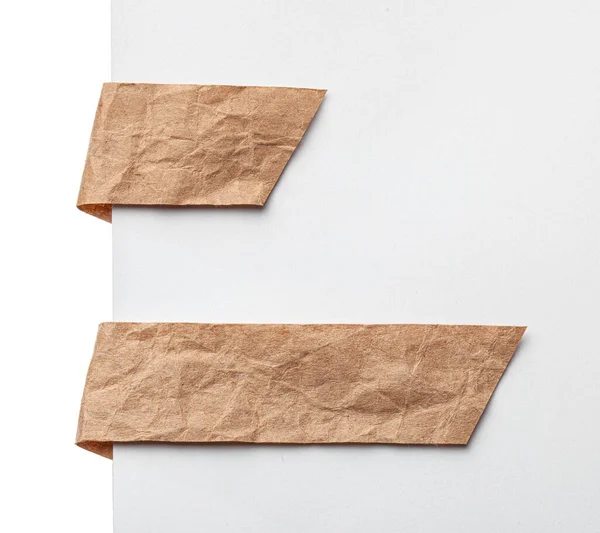 Papírová záložka nebo štítky štítků. Řemeslo zmačkaný papír na bílém pozadí — Stock fotografie