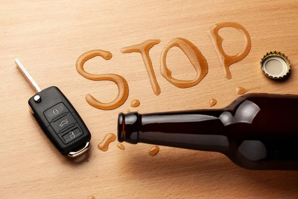 飲酒運転。ビールボトルと単語を停止の形でビールをこぼした。車のキー — ストック写真