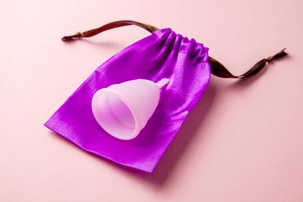 Silikonmenstruationskopp. Kvinnors hälsa och alternativ hygien. Rosa bakgrund. — Stockfoto