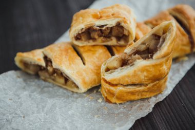 Parşömen üzerinde elmalı ve tarçınlı taze turta ve koyu arkaplan.